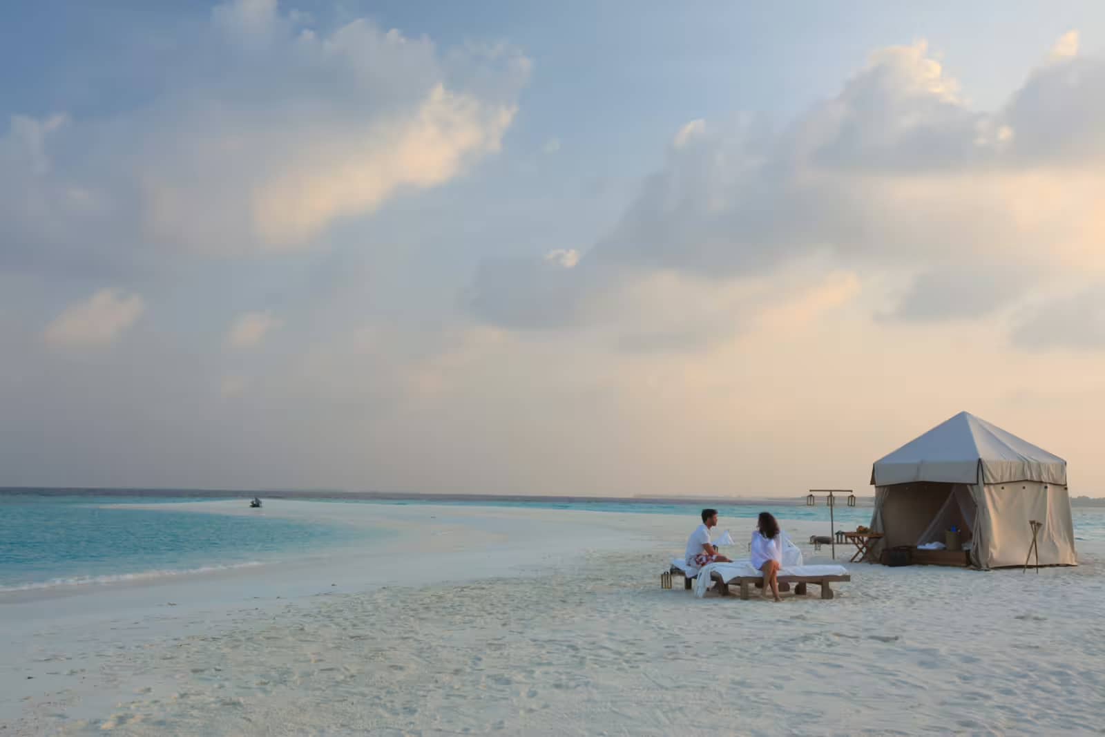 Achtsame Auszeit – Barfuß, Nachhaltig und im Einklang mit Slow Life in Soneva Fushi auf den Malediven 2 Ein paar genießt ein privates Picknick auf einer Sandbank im Hotel Soneva Fushi auf den Malediven