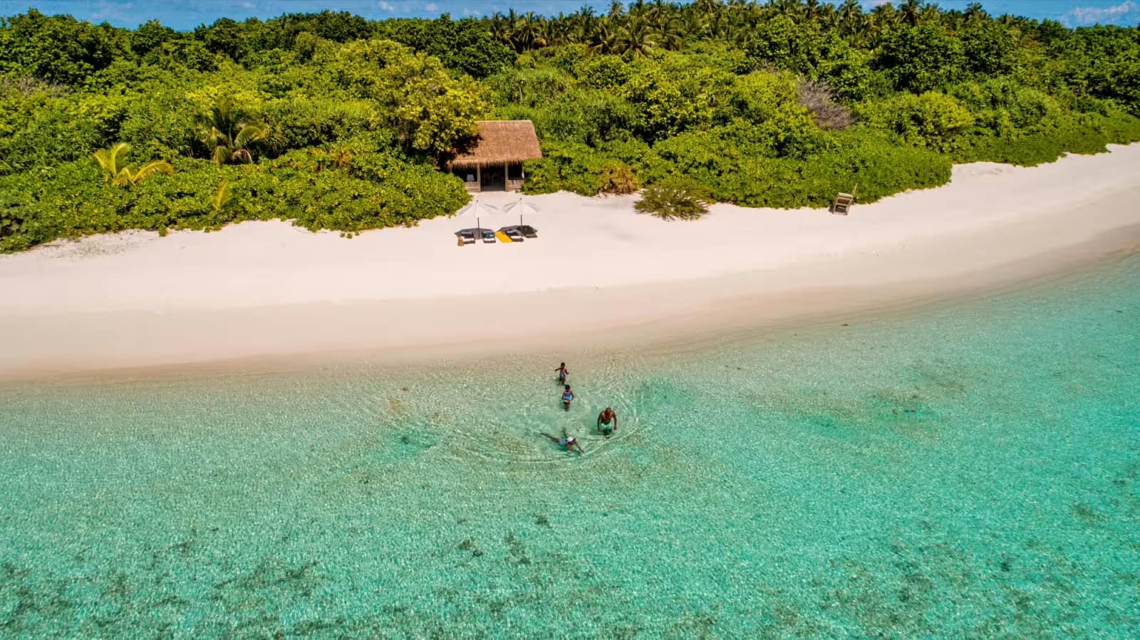 Achtsame Auszeit – Barfuß, Nachhaltig und im Einklang mit Slow Life in Soneva Fushi auf den Malediven 3 Eine Familie badet im türkisen Meer auf der Insel Mendhoo, in der Nähe des Hotels Soneva Fushi auf den Malediven